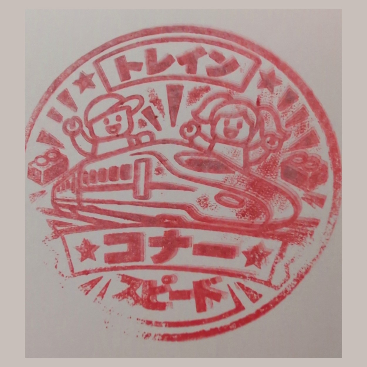 Ink impression of a stamp showing a bullet train and two minifigures